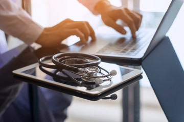 Male doctor hands typing on laptop computer keyboard, search medical information with digital...