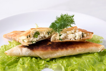 Pita triangles with cottage cheese, herbs, close-up on a white plate