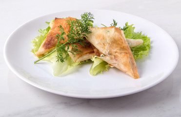 Pita triangles with cottage cheese, herbs, on a white plate
