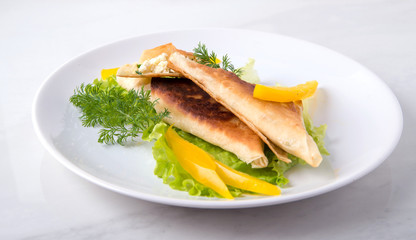 Pita triangles with cottage cheese, herbs, sweet pepper on a white plate