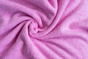 Fototapeta na wymiar Wrinkled light pink microfiber cloth texture of microfiber towel closeup. pink microfiber cloth for cleaning objects and surfaces. Hygienic cleaning towel. fabric background.