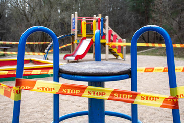 Park kids and children playground for game and activity empty and closed for Coronavirus or Covid19, slide and swing empty tape and strips with word STOP, do not enter, warning sign of quarantine