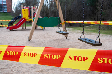 Park kids and children playground for game and activity empty and closed for Coronavirus or Covid19, slide and swing empty tape and strips with word STOP, do not enter, warning sign of quarantine