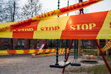 Park kids and children playground for game and activity empty and closed for Coronavirus or Covid19, slide and swing empty tape and strips with word STOP, do not enter, warning sign of quarantine