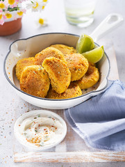 Healthy vegan food, Turmeric quinoa falafel with feta yogurt dip in a bright lunch setting. Selective focus. Middle Eastern platter. Delicious healthy lunch, snack. Diet, vegetarian concept.