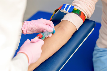 Nurse takes blood from vein.