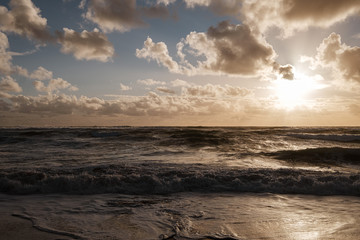Naklejka na ściany i meble Sunset, clouds, beach and sea