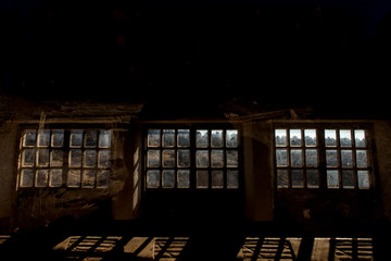 Interior del almacén abandonado, fondo de una antigua nave con pequeñas ventanas y vidrios rotos