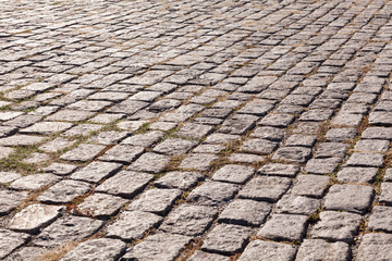 Old cobblestone pavement. Street with granite cobblestoned pavement