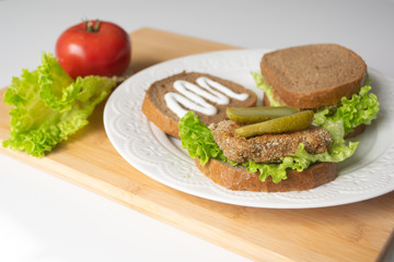 Veggie bean burger sandwiches with mayo, lettuce, tomatoes and pickled cucumber