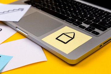 Home office desk workspace with laptop and paper sticker on yellow background. Money, chart, graph...