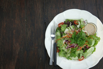 Fresh vegetable slice mix Salad menu in white dish on wood table