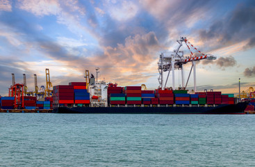Fototapeta premium Logistics and transportation of container ships and cargo with bridges, cranes working in shipyards at sunrise, export and import, in the field of logistics, transportation and transportation industr