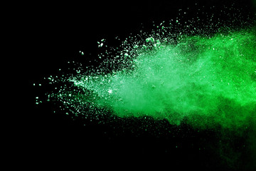 Green powder explosion on black background.