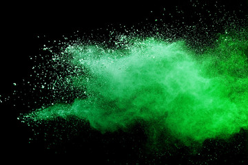 Green powder explosion on black background.