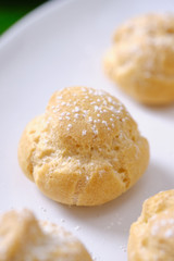 choux cream or cream puff or French profiteroles with fresh cream set on cafe table.