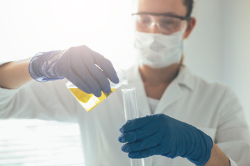 Close up laboratory employee holding test tubes and doing laboratory work