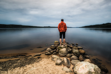 Man standing alone at lake, Sweden.