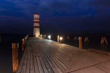 Neusiedl am See - Lake Neusiedl, old wooden pier leading to the white-red lighthouse with night sky