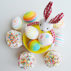 Easter. Colored eggs and cakes. Festive rabbit. Design for postcards.