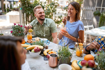 Friends at the table outside drinking juice and having fun