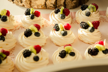 Frische Sahne Baiser mit Himbeeren Blaubeeren und Kiwi