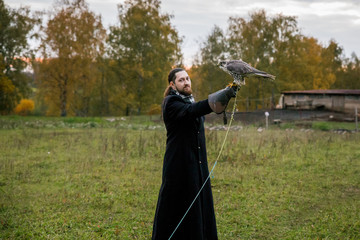 The concept of falconry. A man of European appearance with beard, with a leather glove and a...