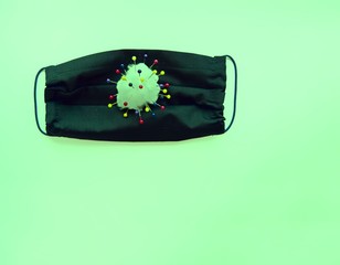 medical black mask with a virus on a green background