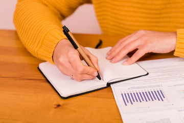 chica anotando en un block la economía doméstica