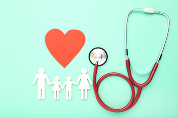Stethoscope with red paper heart and family figure on mint background