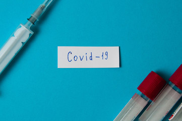 Coronavirus medicine and treatment concept. Note of coronavirus COVID-19. Syringe and blood test...