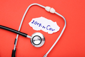 Text 2019-nCov with stethoscope on red background