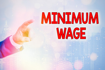 Writing note showing Minimum Wage. Business concept for the lowest wage permitted by law or by a...
