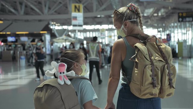 Woman and child baby tourist caucasian at airport with wearing protective medical mask. Family in quarantine isolation. Health safety virus protect coronavirus epidemic sars-cov-2 covid-19 2019-ncov.