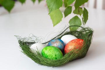 Easter - pascha, blue, green, red, white egg in grassy basket