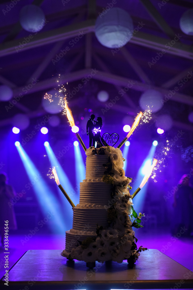 Wall mural a wedding cake with silhouette of bride and groom