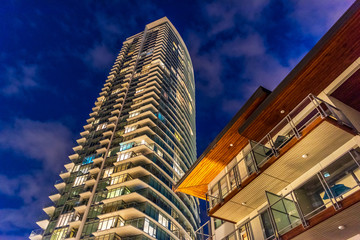 House building and city construction concept: night outdoor urban view of modern real estate homes.