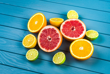 juicy oranges, grapefruits, limes and lemons lie on a blue wooden table