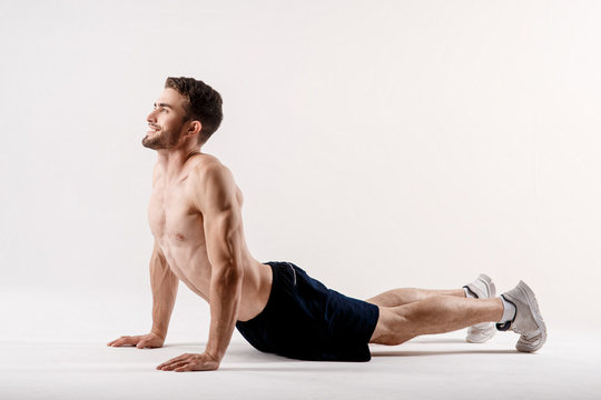 A man on a white background does an exercise on stretching his back. straight loin yoga exercise
