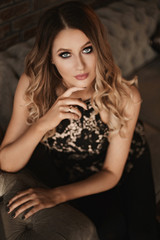 Fototapeta premium Young woman with blond hair and perfect trendy makeup. Beautiful blonde model girl with modish makeup, deep blue eyes and seductive look. Concept of modish official makeup and smooth skin