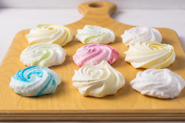 Homemade sweet colored meringue on wooden background.  .Dessert.