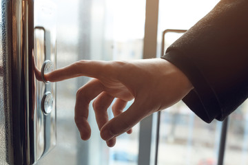 Finger presses the elevator button. Businessman pushing up elevator button. Human hand reaches for the button of the elevator call. © maxbelchenko