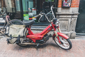 ancient moped parked in front of an establishment