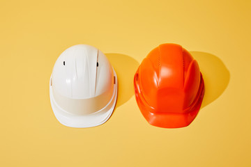 top view of orange and white helmets on yellow background