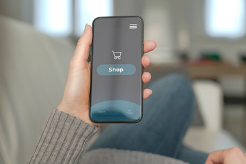 A young woman use the smartphone for shopping online on the sofa at home