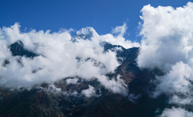 Fototapeta premium Szczyt górski Thamserku 6608m pokryty chmurami zdjęcia krajobrazu we wschodnich Himalajach Nepalu.