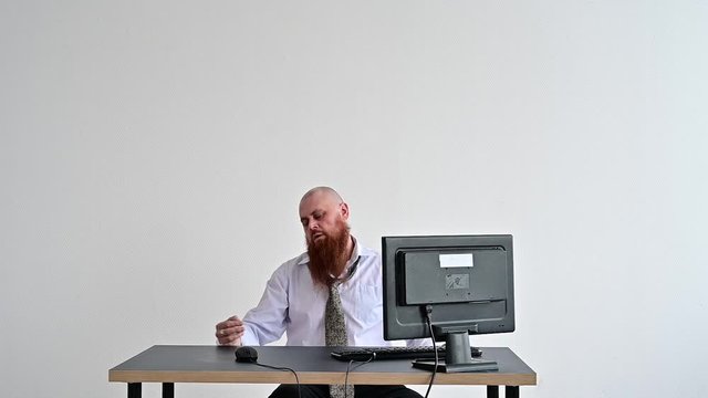 Stressed crazy businessman smashing his computer in office using ax problem concept. The man has problems at work and frustration.