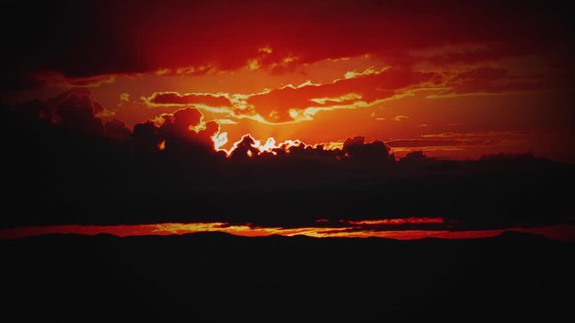 Fire Red Sunrise behind Storm Clouds Zoom In Time-lapse