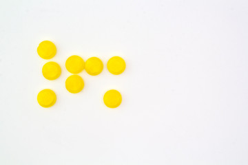 yellow pills on white background