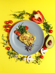 Culinary dishes made from natural products on a colored plate on a background with ingredients for cooking. Healthy eating concept. Top view.